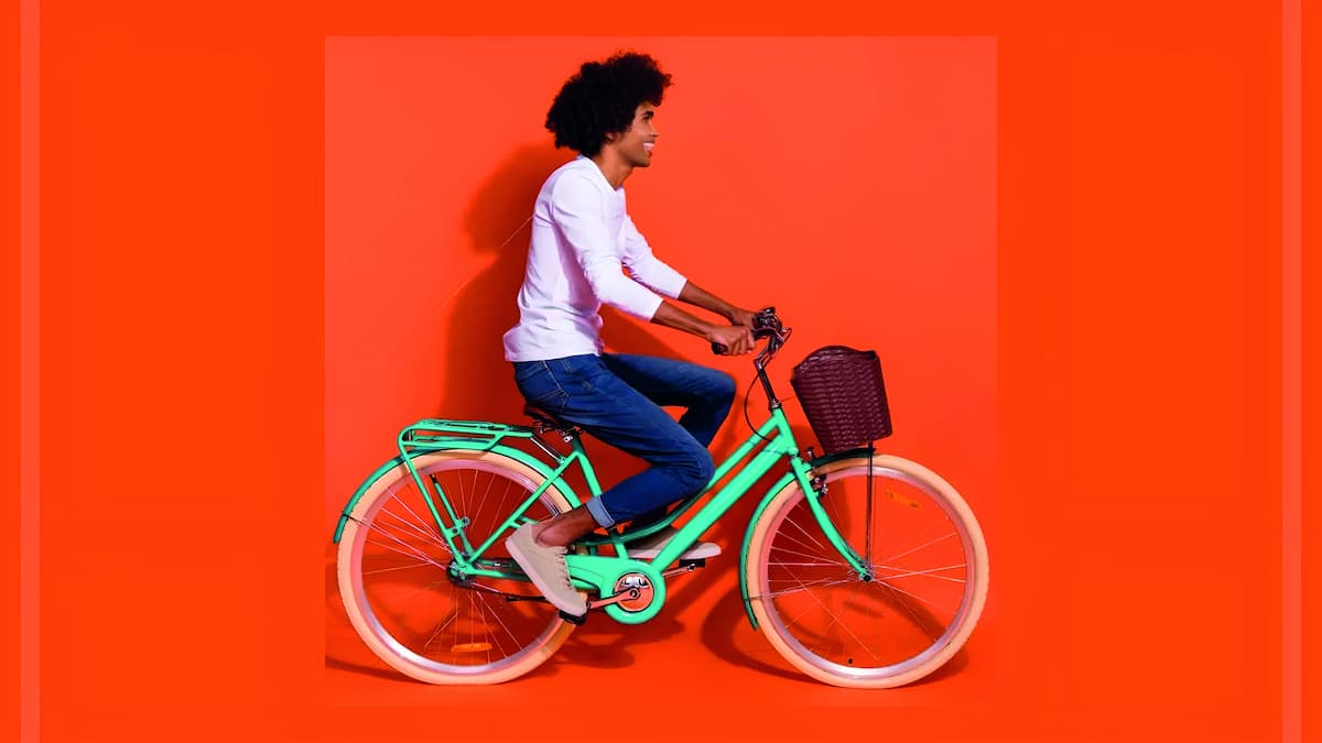 oven andando en bicicleta azul, fondo naranja- Repuestospara Bicicletas.com - portada