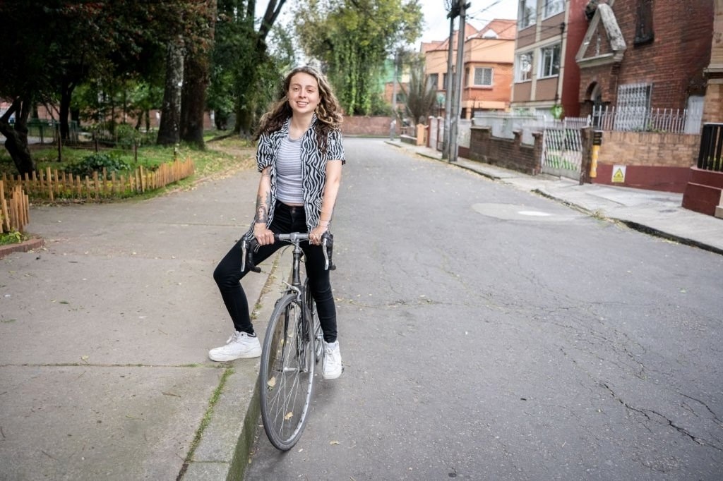 Mujer montando bicicleta y escuchando música.