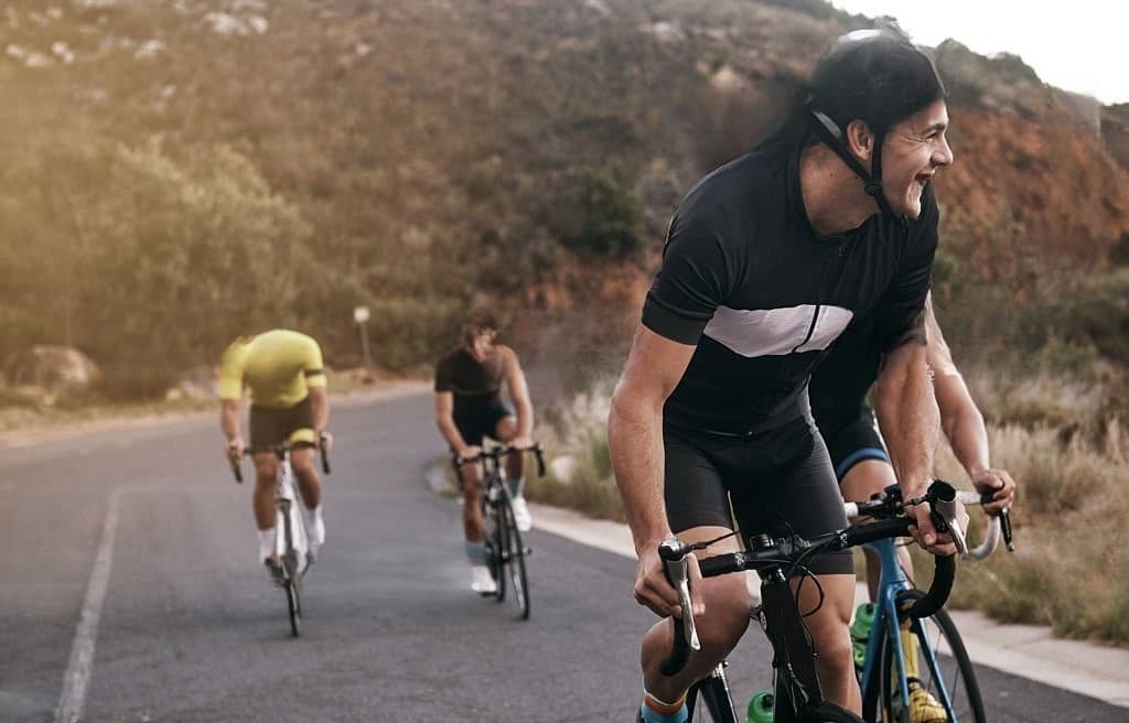 Grupo de ciclistas sonriendo recorriendo la Bogotá - Acelera en Bogotá con Bicicletas de ruta