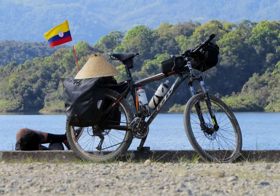 Persona junto a río en su bicicleta - Bicicletas de ruta en Colombia: Pasión sobre pedales