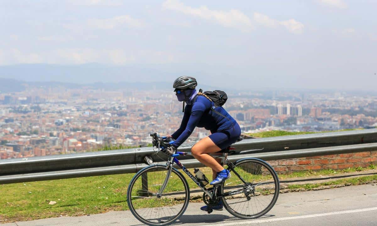 Ciclista con panorámica de Bogotá de Fondo - Pedalea hacia la Naturaleza Bogotá y sus Rutas Verdes en Bici